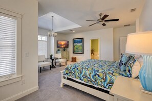 A bedroom with a bed, a desk, a chair, a television, a ceiling fan, and a window with blinds. - 205 Jacana-"The Sandy Pelican" only a few sandy steps (93 yards) to the beach (Hilton Head)