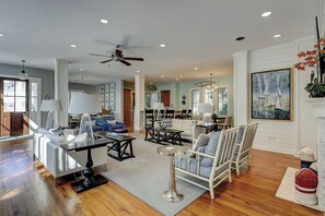 A spacious living room with a fireplace, a dining area, and a kitchen in the background. - 205 Jacana-"The Sandy Pelican" only a few sandy steps (93 yards) to the beach (Hilton Head)