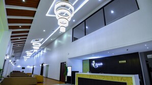 A modern reception area with a reception desk, seating area, and a chandelier. - Spoorti Resort and Club (Bijapur)