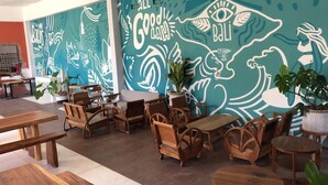 A café with wooden furniture and a mural with hand-drawn illustrations and text.
