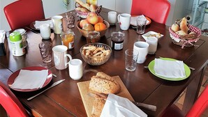 Een ontbijttafel gedekt met diverse producten, zoals brood, fruit en drankjes.