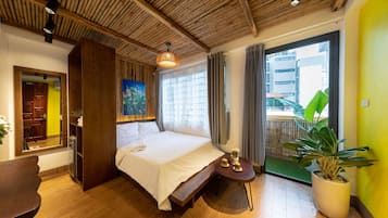 Une chambre moderne avec un plafond en bois, un grand lit, une petite table avec une plante et une vue sur un bâtiment à l’extérieur.