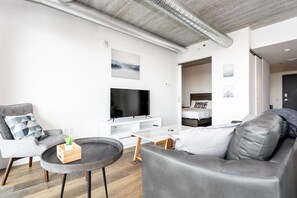 Relax in this stylish living room with a grey sofa, coffee table, and armchair, perfect for unwinding in comfort.