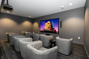 Enjoy movies in this cozy home theater with a flat-screen TV, comfortable seating, and a projector.