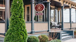 A traditional building with a porch, a signboard, and a well-maintained lawn. - The Serendipity Suite (Staunton)