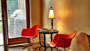 A room with two rocking chairs, a small table with a lamp, and a window with blinds. - Carbondale Townhome with A/C, WiFi, and Backyard (Carbondale)
