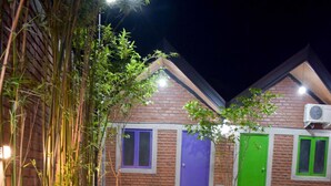 A building with a brick facade, a small water feature, and a variety of plants. - Laana Villa (Negombo)