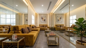 A modern lounge area with sofas, tables, and artwork.