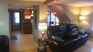 A living room with a leather sofa, a lamp, and a wooden coffee table.