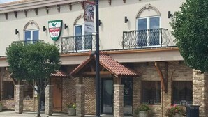 A building with a sign for 'Mirelo's Pizza' and a 'Village of Crete' sign.