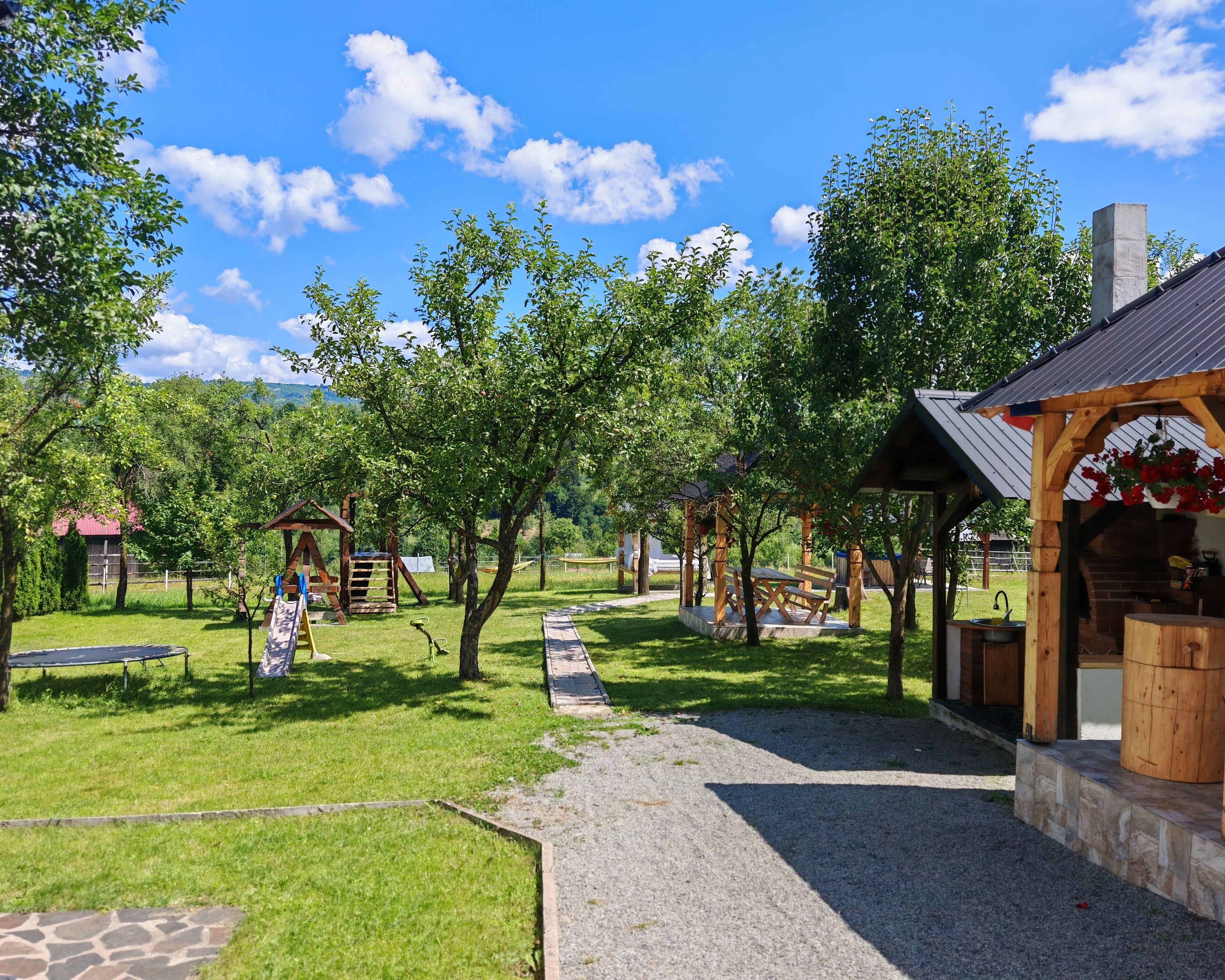 A park with a wooden gazebo, picnic tables, and a playground.