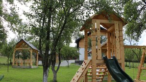 Eine Holzspielkonstruktion mit Rutsche und Kletterbereich in einem Park.