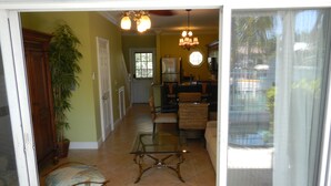 A spacious living area with a glass coffee table, a cushioned bench, and a dining table with chairs. - PLUNGE POOL VILLA ON BLUE WATER LAGOON DUCK Key/MARATHON, FL (Marathon)