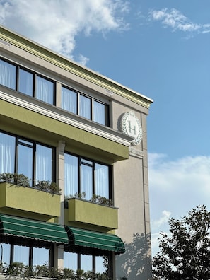 A hotel building with a balcony, large windows, and a prominent emblem on the facade. - Lord Hotel & Restaurant at AutoStation (Preze)