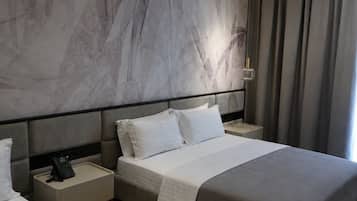 Ein modernes Hotelzimmer mit einem großen Bett, Nachttischen und einer Wand mit Marmoroptik.
