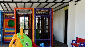 Uma área de recreação infantil com estrutura de escalada e escorrega.