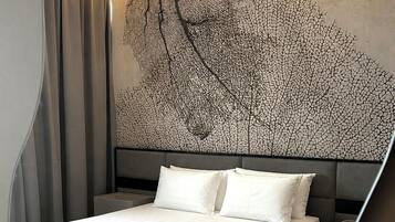 Un dormitorio moderno con una cama grande, un cabecero con diseño de árbol y suelo de madera.