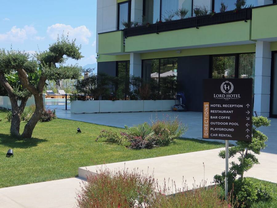 A hotel sign with directions to amenities including a restaurant, bar, outdoor pool, playground, and car rental.