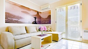 A modern living room with a sofa, a coffee table, and a large cityscape painting on the wall.