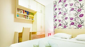 A hotel room with a bed, a desk, and a wardrobe.