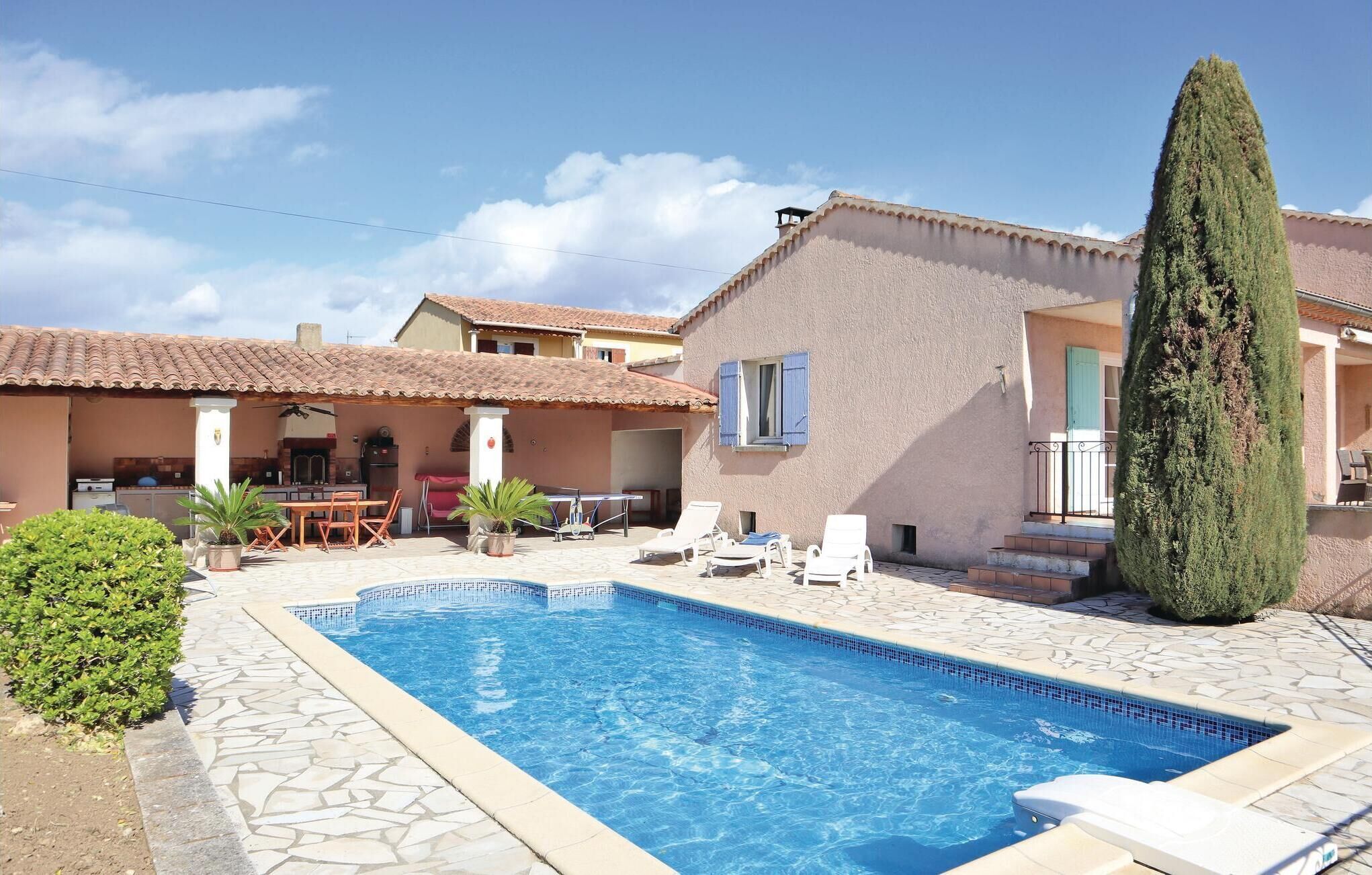 Ein Swimmingpool mit Liegestühlen, einer überdachten Terrasse und einer hohen Nadelbaum-Eiche.