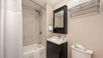 Un bagno moderno con doccia, vasca, lavabo e porta asciugamani.