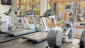 Une salle de sport équipée de tapis de course, d’elliptiques et d’un vélo d’appartement.
