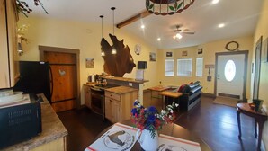 Un salón amplio con cocina, una mesa de comedor y un mueble de madera grande.