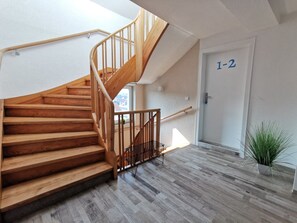 A wooden staircase with a metal handrail leading to a landing. - New accommodation directly adjacent to Kassel (up to 18 pers.) (Kirchbauna)