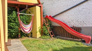 A backyard with a red slide, a hammock, and a wooden ladder. - New accommodation directly adjacent to Kassel (up to 18 pers.) (Kirchbauna)