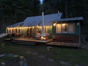 A cabin with a covered porch, a fireplace, and outdoor seating. - Pet Friendly Quiet Cabin with Privacy, Hot Tub, and Backcountry Access. (Ketchum)