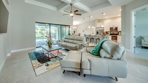 A spacious living room with a large sofa, a coffee table, and a dining area. - Stunning! Private Villa with pool, for families. No storm damage.  (Cape Coral)