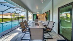 A covered outdoor area with a pool, a table with chairs, and a view of the surrounding landscape. - Stunning! Private Villa with pool, for families. No storm damage.  (Cape Coral)