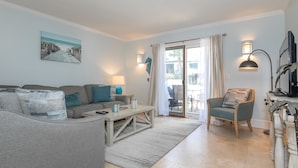 A living room with a sofa, armchairs, a coffee table, and a TV. - 3 Ocean Club : Steps to the beach, pool outside your door (Hilton Head Island)
