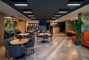 A modern hotel lobby with multiple seating areas, a reception desk, and a bar. - Labirint Hotel (Bucharest)