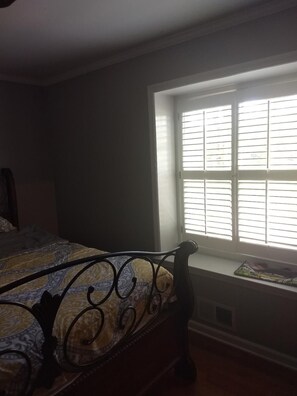 Cozy retreat with a single bed, window with blinds, and a reading nook.