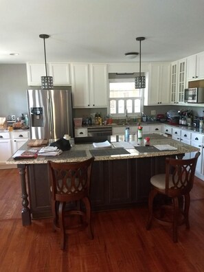 Enjoy cooking in this well-equipped kitchen with a central island and stainless steel appliances.
