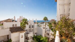 Zona residencial a la costa amb edificis blancs, alguns amb teulades de rajola, i palmeres.
