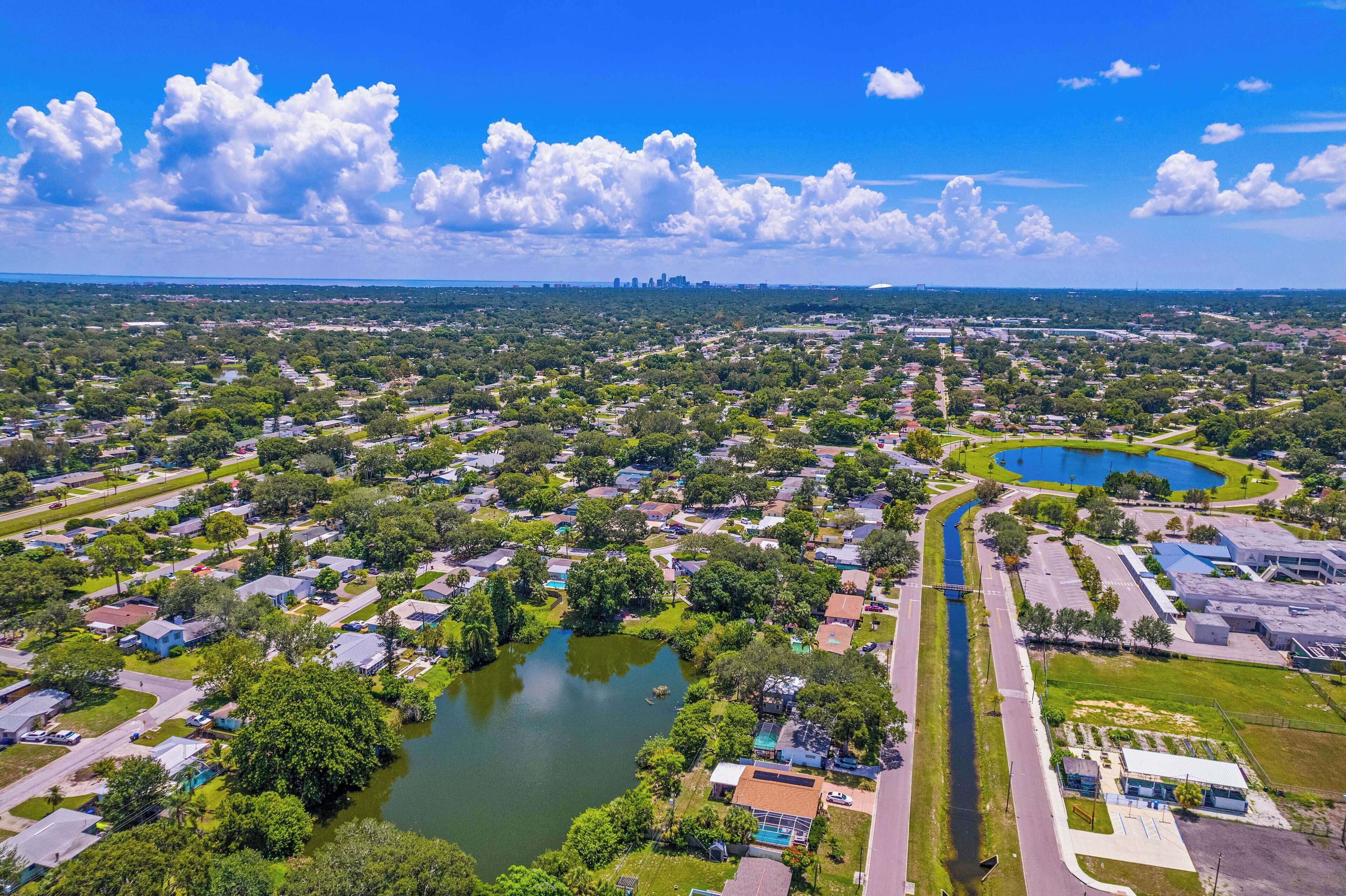 Vue aérienne d’un quartier résidentiel avec des maisons, un lac et une route.