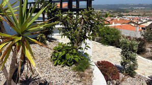 A balcony with a view of a town, surrounded by various plants and a white wall. - Sítio do Louro Villa - Deluxe Villa w/ gaming room (São Martinho do Porto)