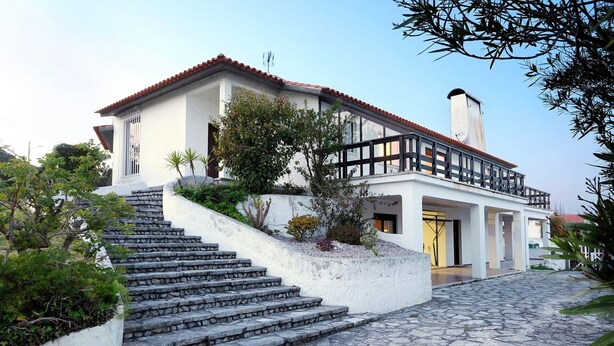 A two-story house with a stone staircase leading to the entrance, surrounded by greenery and a cobblestone driveway. - Sítio do Louro Villa - Deluxe Villa w/ gaming room (São Martinho do Porto)