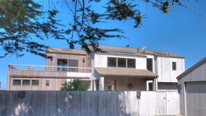 A two-story house with a balcony, a garage, and a fenced yard. - Galleon's Reach- Pebble Beach & Black Point Access (Sea Ranch)