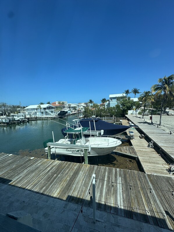 Stunning marina views with boats docked at the piers, adjacent to a serene beach and palm trees.