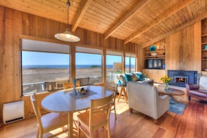 Un interior de madera con comedor, asientos y chimenea.