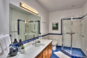 A modern bathroom with a glass shower enclosure, a large mirror, and a white sink with a vanity. - Sculpture Point - Sea Ranch Whitewater Vista Lodge (Sea Ranch)