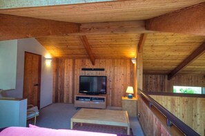 A wooden interior with a television, a sofa, and a lamp. - Kenber House – Don Jacobs Coastal Near Shell Beach (Sea Ranch)