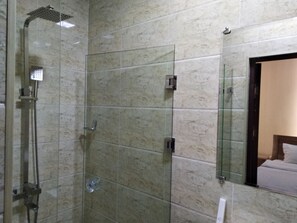 A bathroom with a glass shower enclosure, a handheld showerhead, and a wall-mounted faucet. - Chinor Garden Hotel (Tashkent)