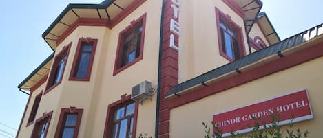 A corner building with a sign reading "CHINOR GARDEN HOTEL".