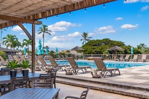 A poolside area with lounge chairs, a pool, and a covered seating area. - Bright and Cozy Studio with Ocean View-Maui Eldorado J218 (Lahaina)