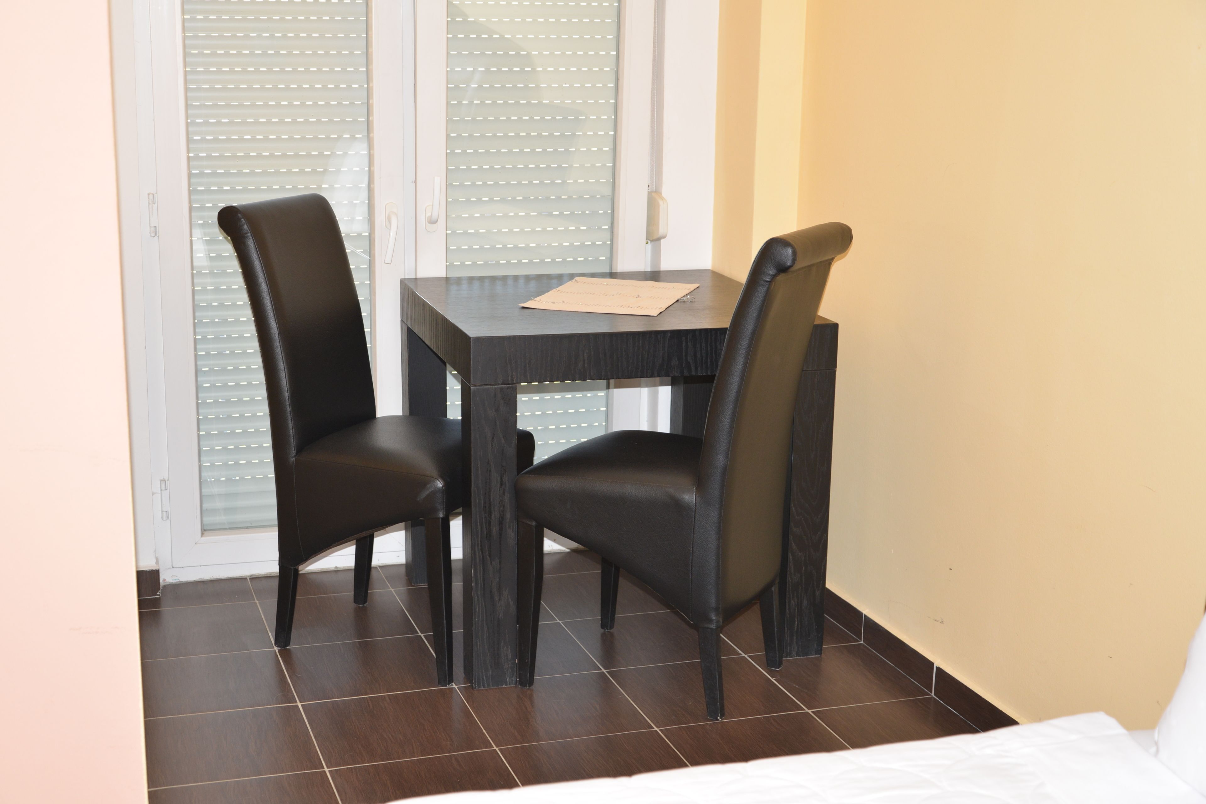 Una habitación pequeña con cama, una mesa y dos sillas.